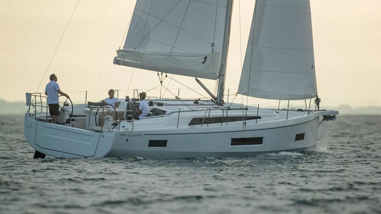 Beneteau Oceanis 40.1 under sail off a wooded coastline
