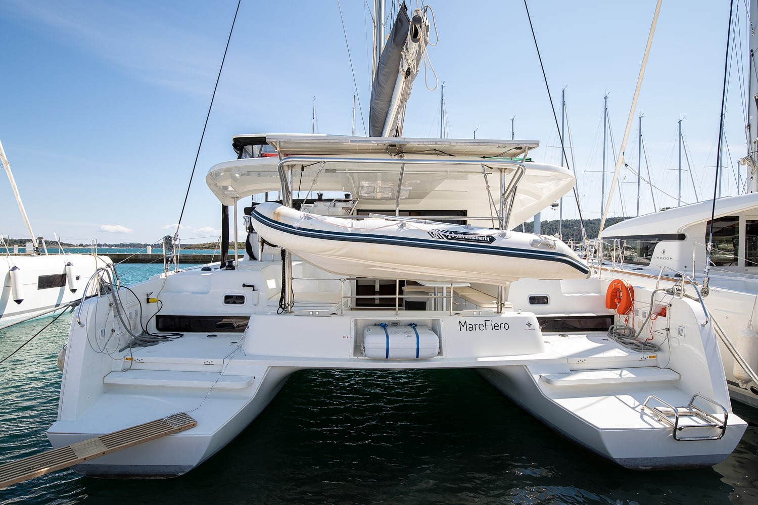 Stern of the Lagoon 42 Mare Fiero with the dinghy raised on davits and two wide bathing platforms