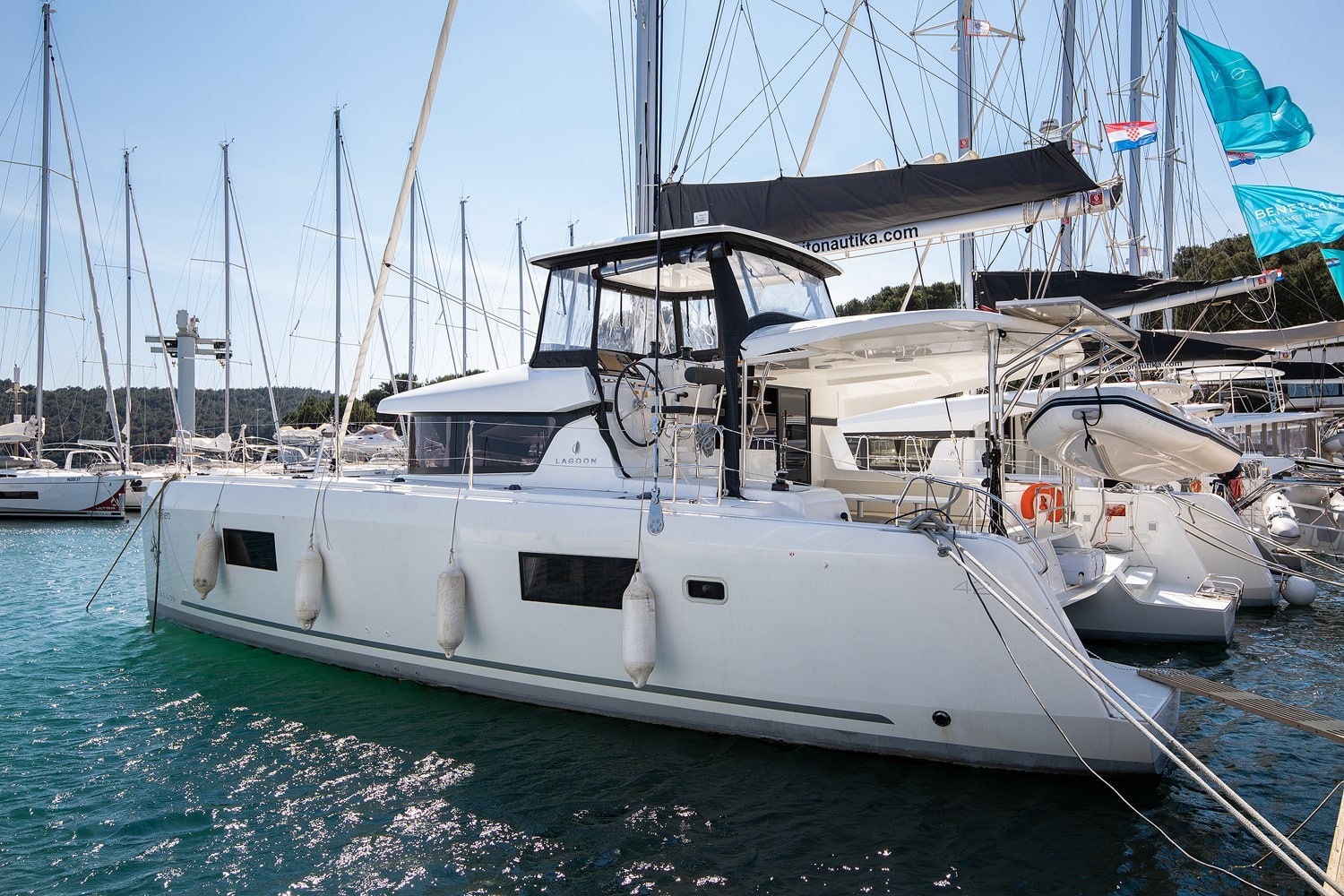 Lagoon 42 Mare Fiero seen from the bow quarter, showing the full hull and raised helm position