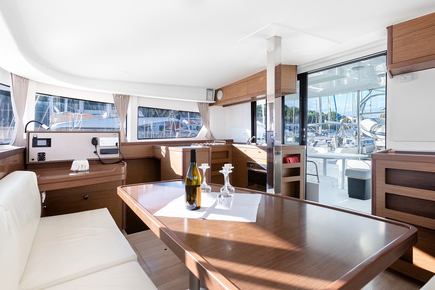 Saloon table of the Lagoon 42 looking aft towards the galley and the open cockpit door