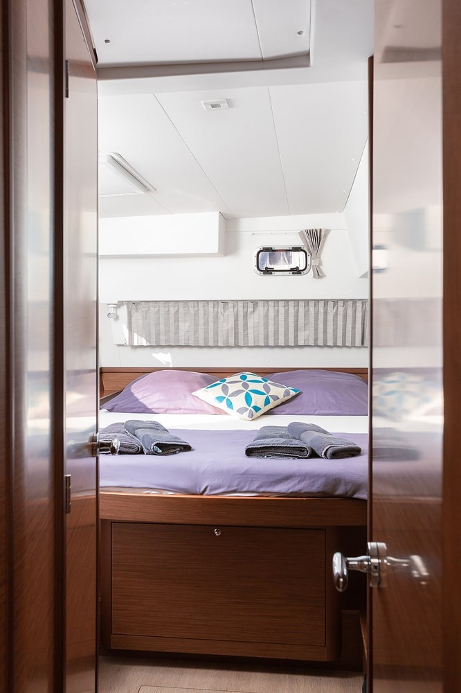 View through the cabin door into a double cabin of the Lagoon 42 with made-up bed