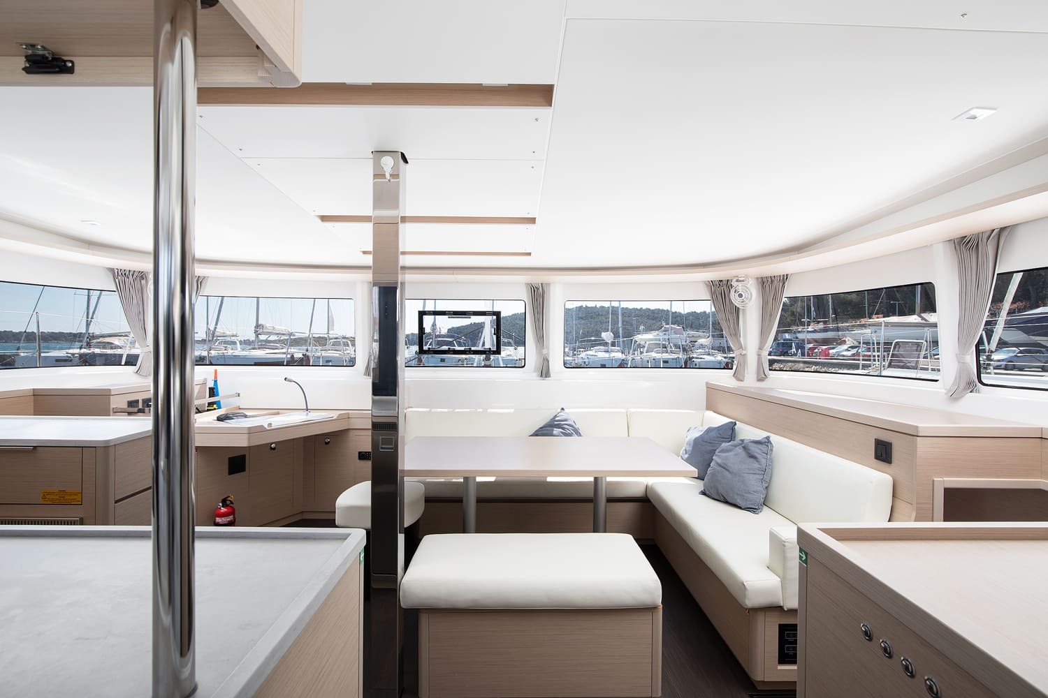 Saloon of the Lagoon 46 with galley to port, L-shaped settee and dining table, panoramic windows and light oak joinery