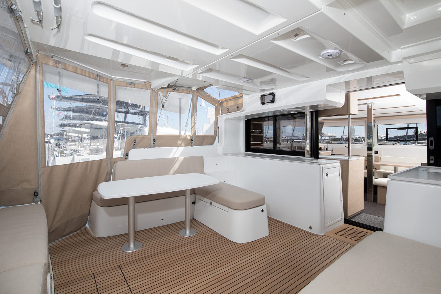 Cockpit dining area of the Lagoon 46 with table, bench seats, cockpit tent panels and teak sole