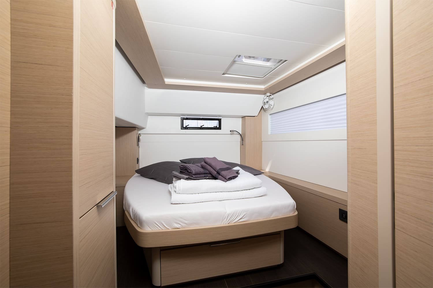 Double cabin on the Lagoon 46 with island berth, drawer storage beneath, cabin fan and full-height wardrobes either side