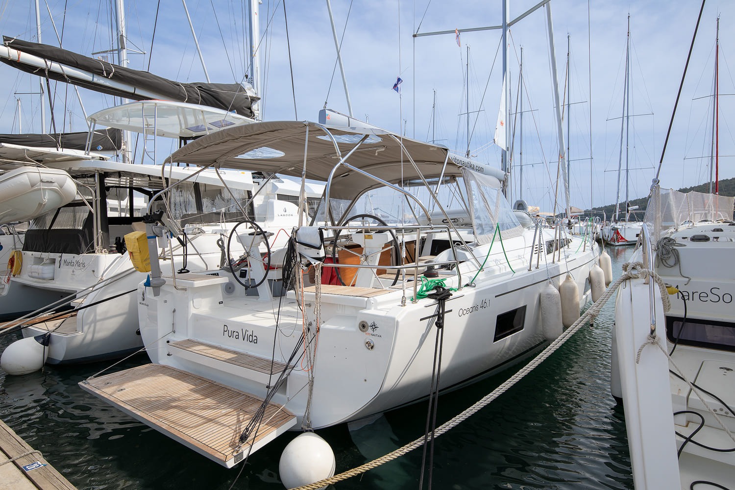 Pura Vida, a 2023 Bénéteau Oceanis 46.1, moored stern-to at ACI Marina Pomer with her bimini up and fenders out