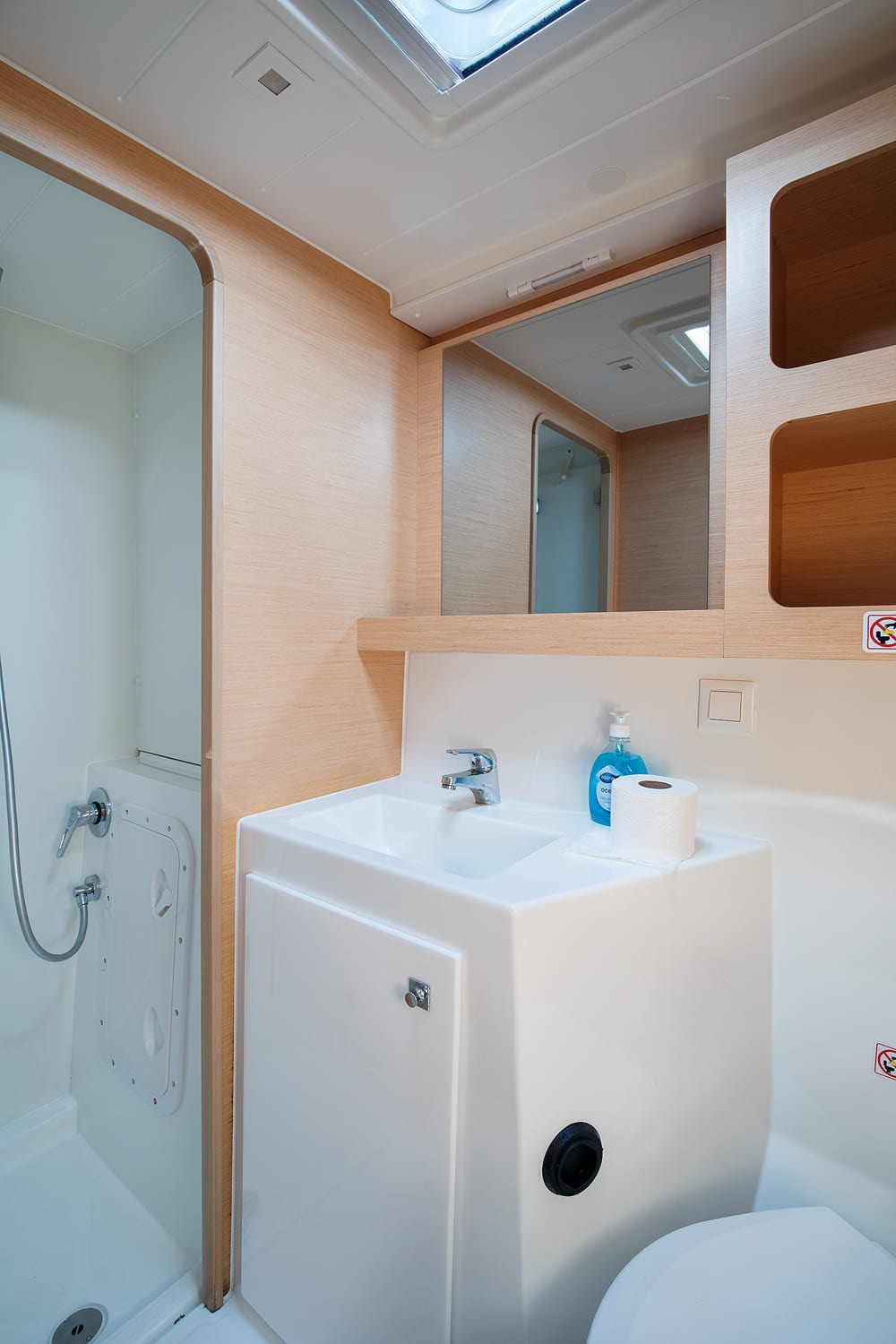Heads compartment with a separate shower cubicle alongside the washbasin and mirrored shelf.
