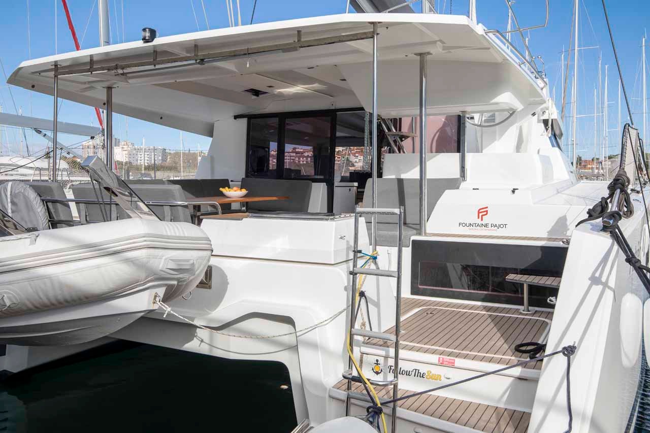 The cockpit and bathing platform of the Astrea 42, with the boarding ladder down and the Fountaine Pajot logo on the coachroof.