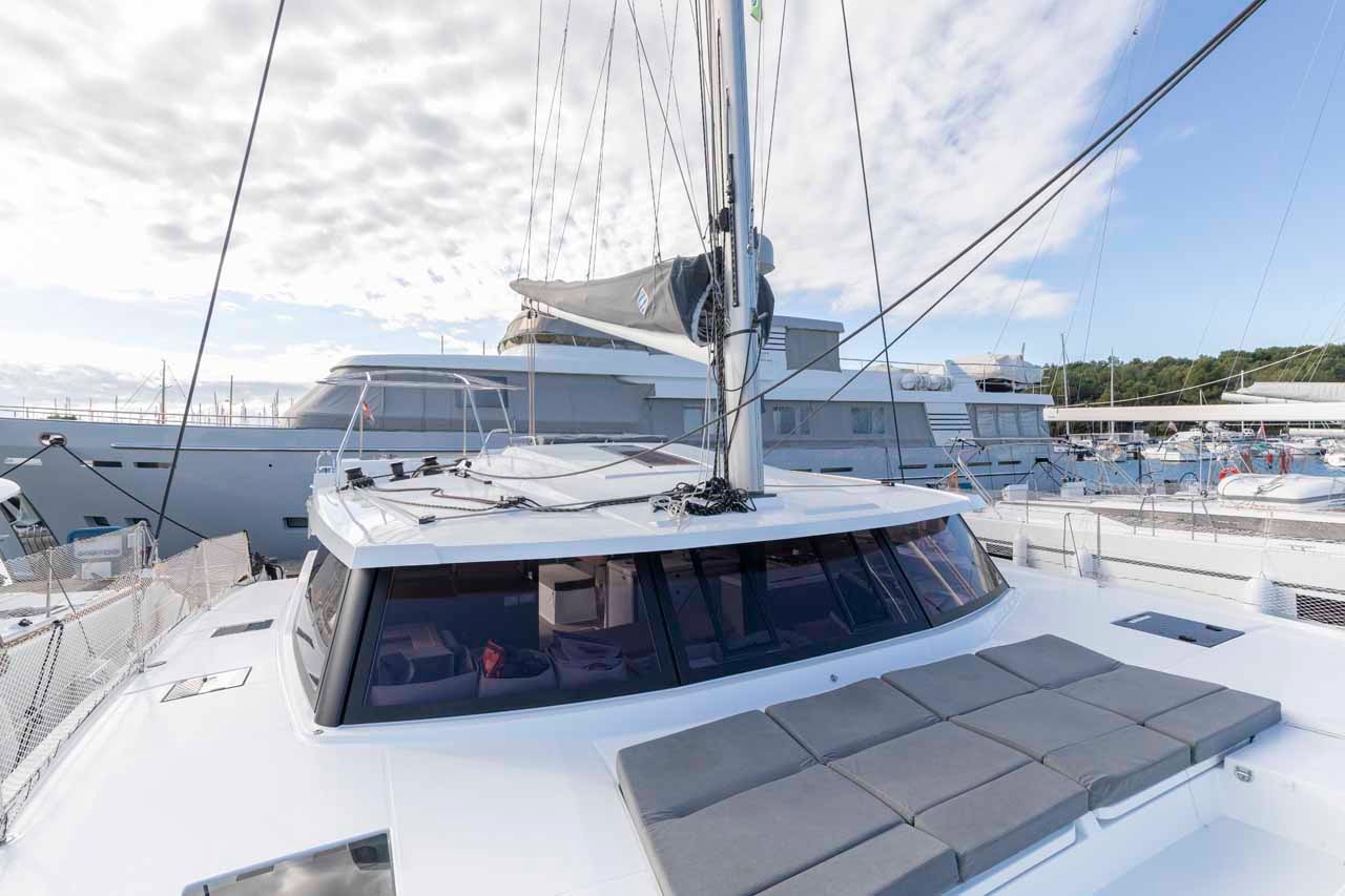 The flybridge sunbed on the coachroof of the Astrea 42, with the mast and panoramic saloon windows behind.