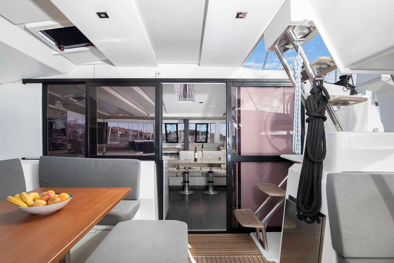 Looking from the cockpit into the saloon of the Astrea 42 through the open sliding door, with the dining table set in the foreground.