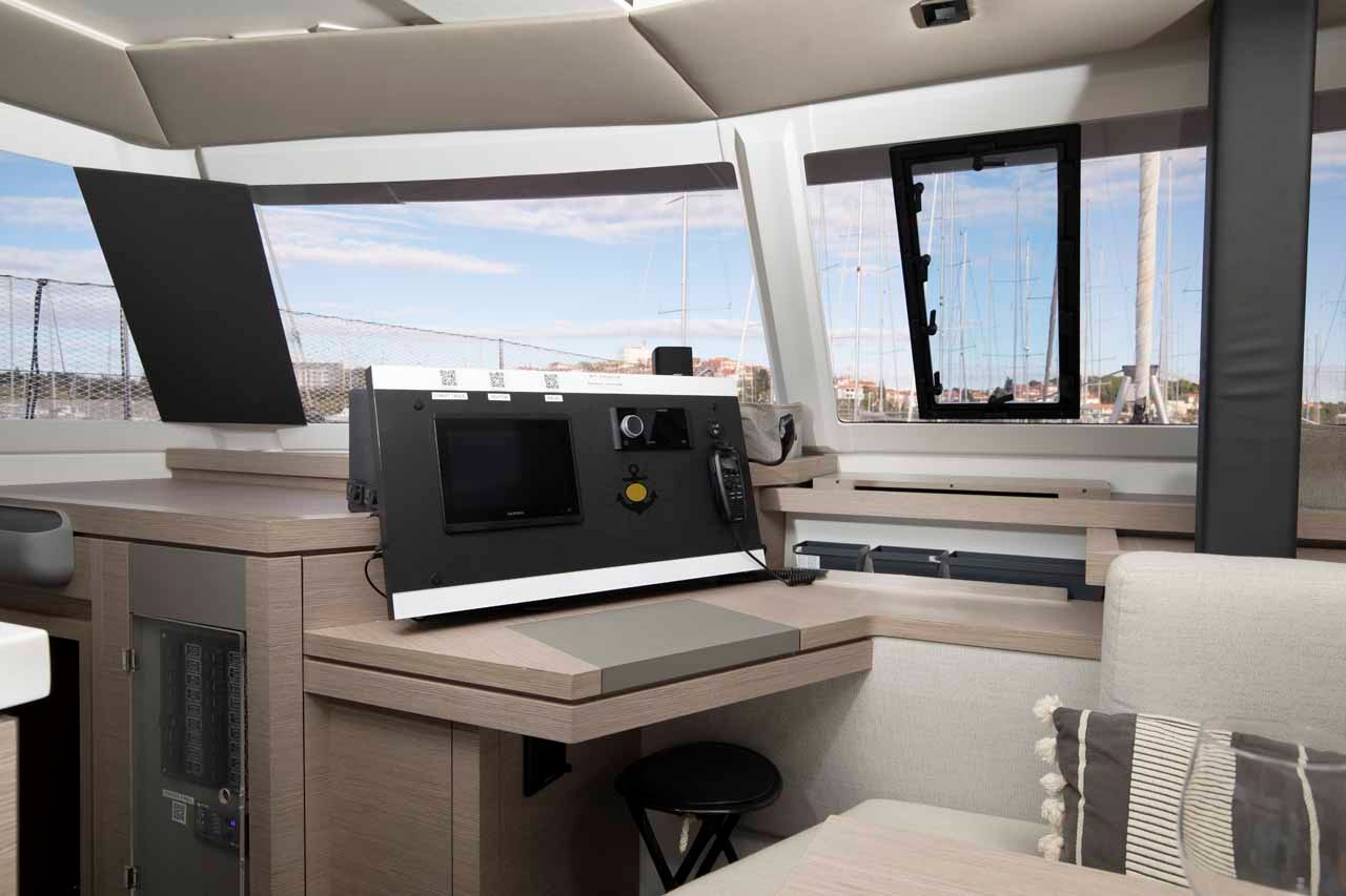 The navigation station of the Astrea 42, with a chart plotter, VHF handset and the main electrical panel alongside.
