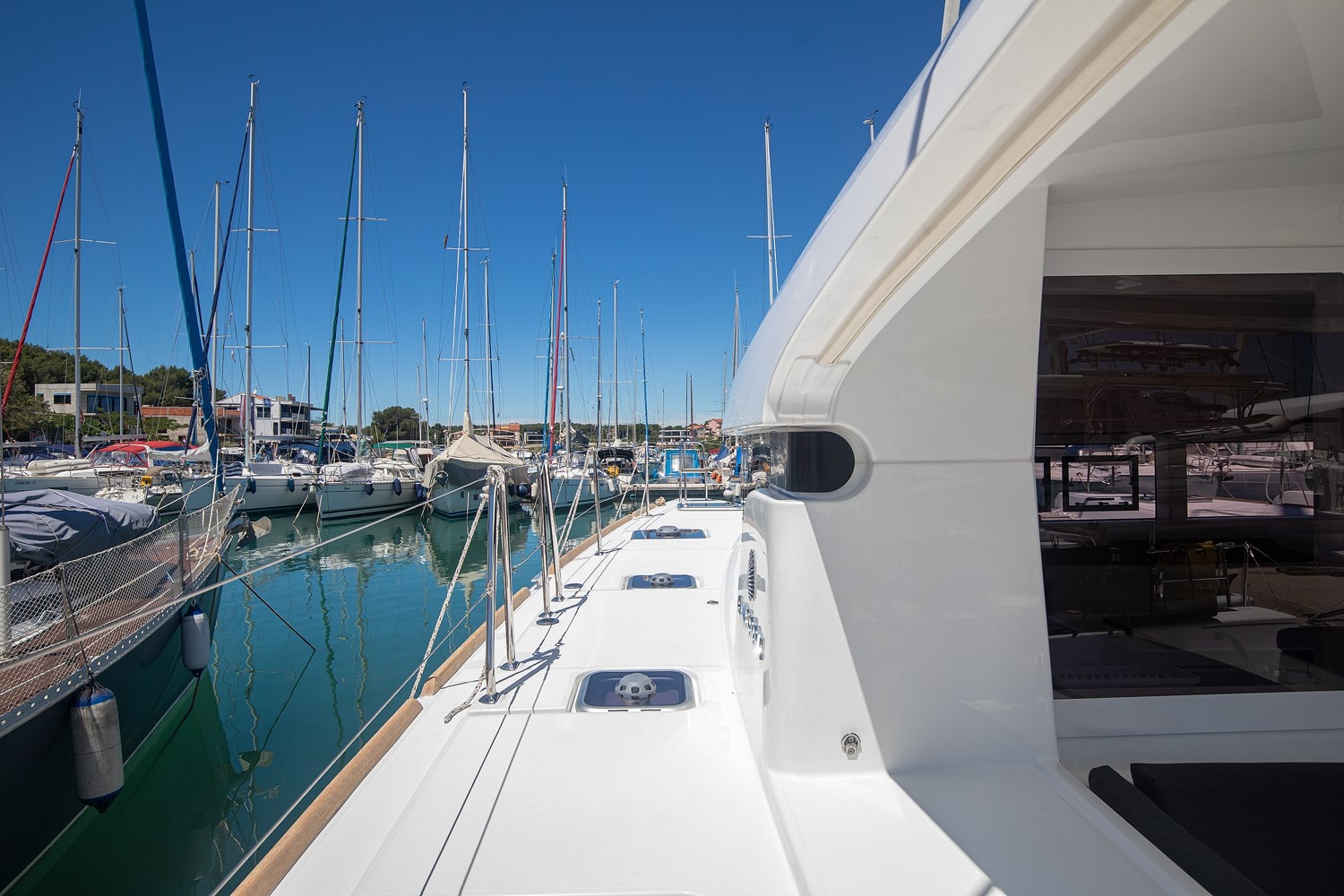 Side deck running forward along the coachroof, with grab rails, deck hatches and mooring lines led aft