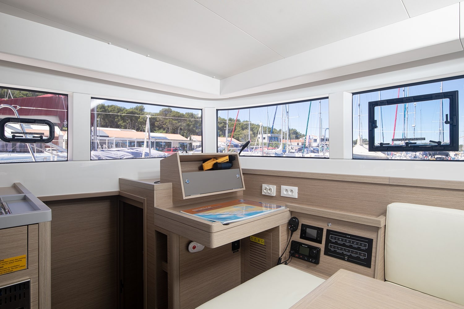 Navigation station in the saloon, with a chart desk, instrument panel, switch panels and panoramic windows