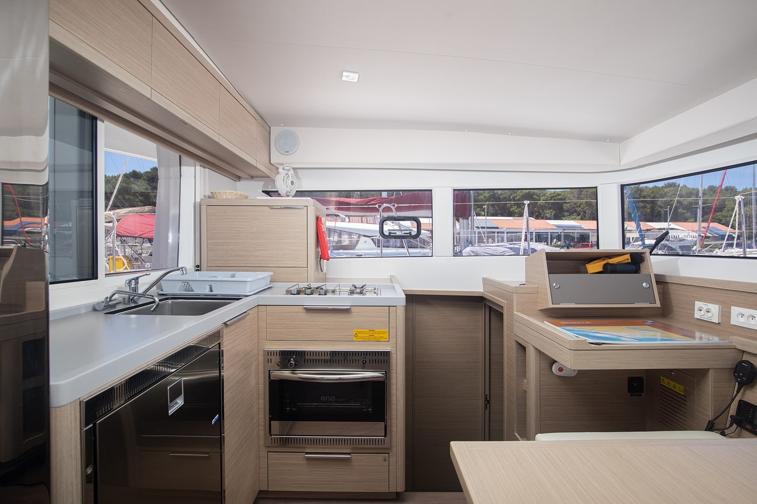 Galley with a gas hob, oven, twin sink and fridge, set along the port side under the saloon windows