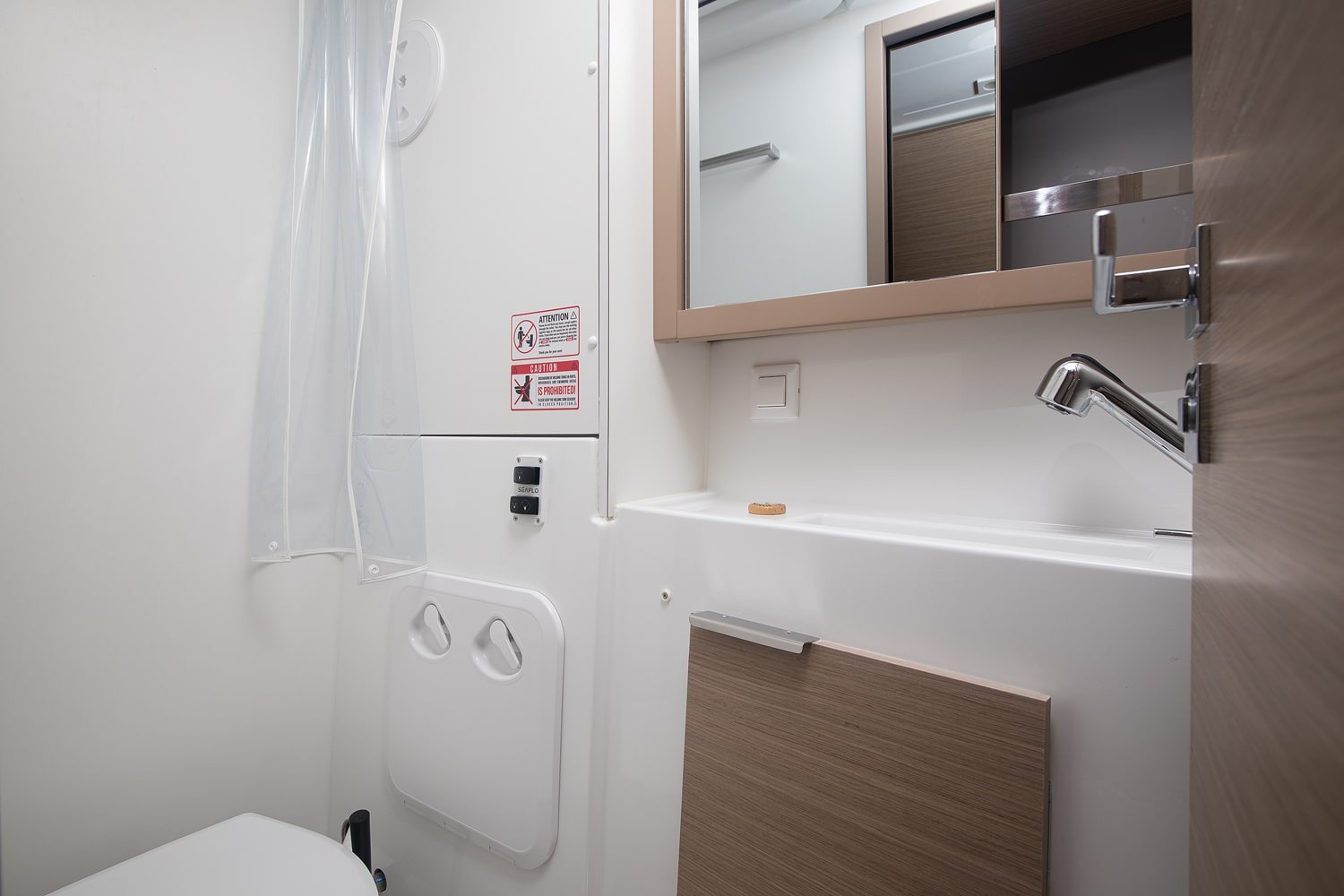 Heads compartment with a shower curtain, mirrored cabinet, washbasin and electric toilet