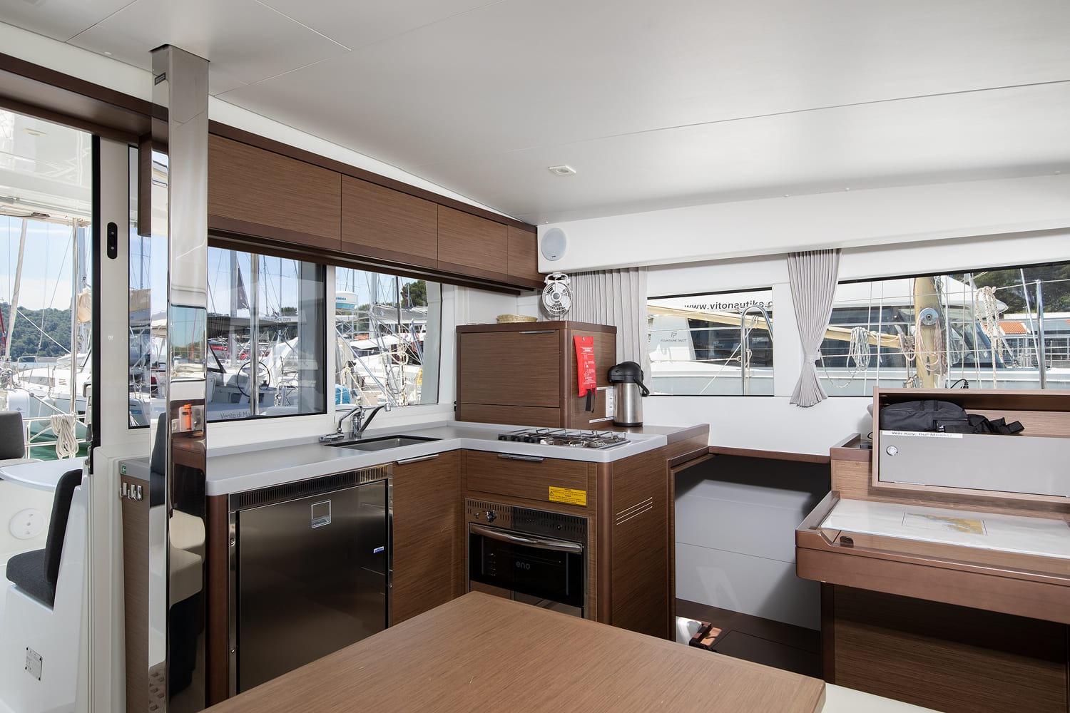 Galley with sink, gas hob, oven and fridge, and the sliding door leading out to the cockpit.