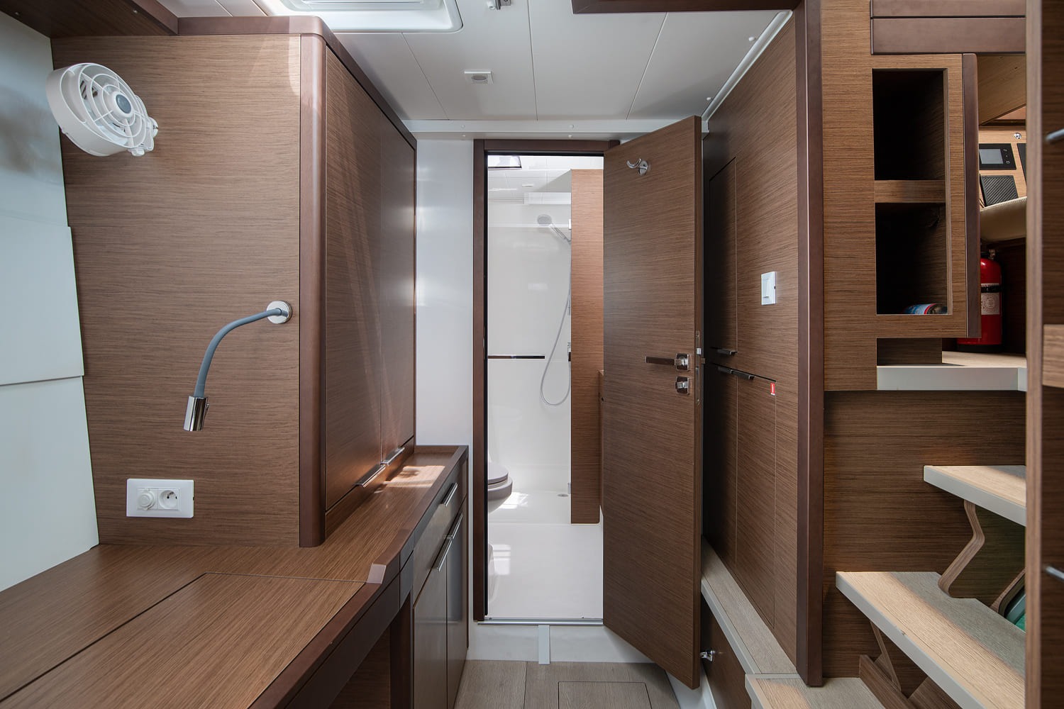 Passage in the hull leading to the heads with a separate shower cubicle, with worktop and storage alongside.