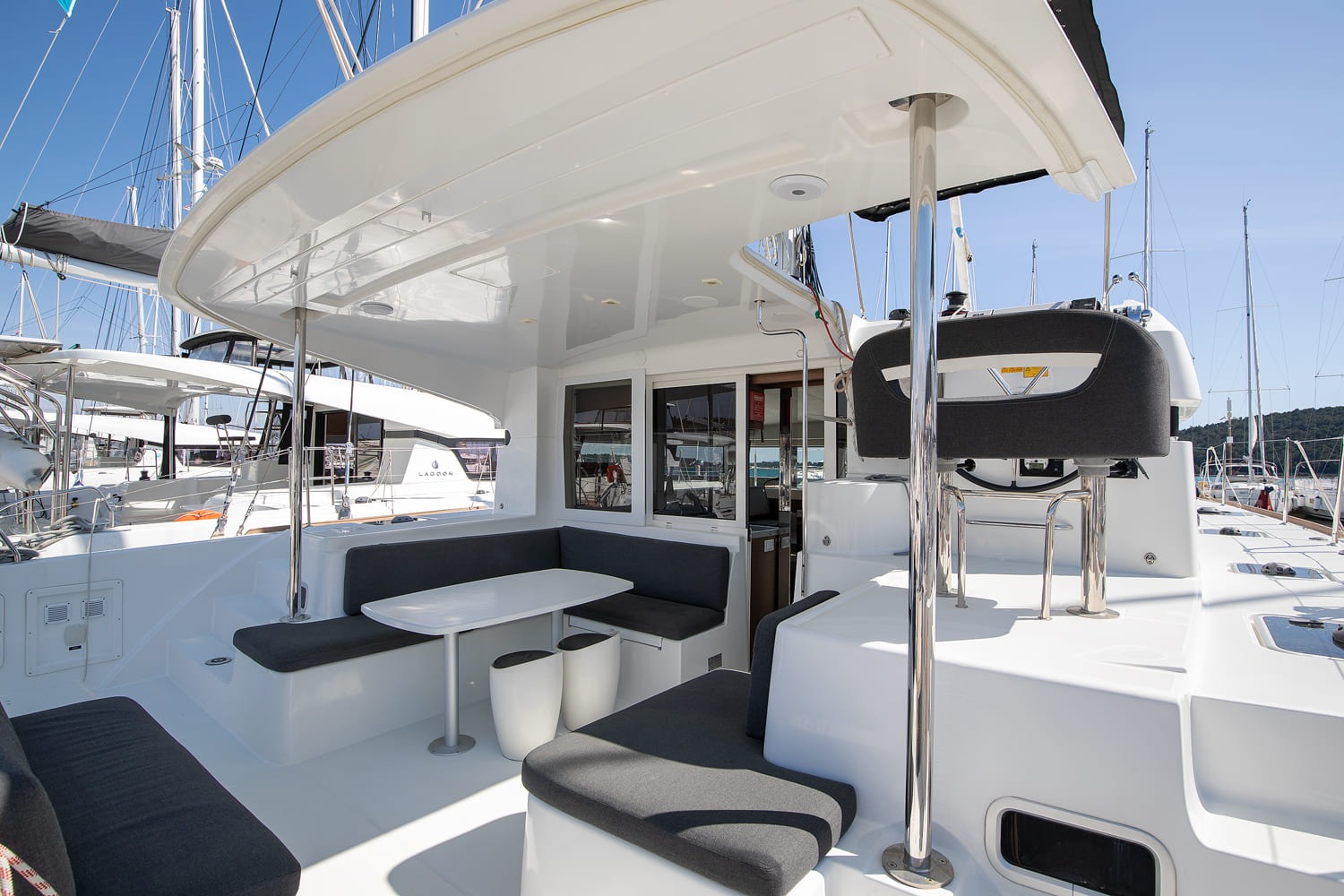 Cockpit under the hardtop with dining table, grey cushions and the starboard helm seat, moored in ACI Marina Pomer