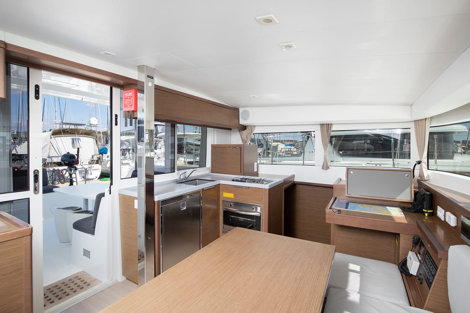 Saloon looking aft to the galley and the sliding doors out to the cockpit, with fridge, oven and chart table