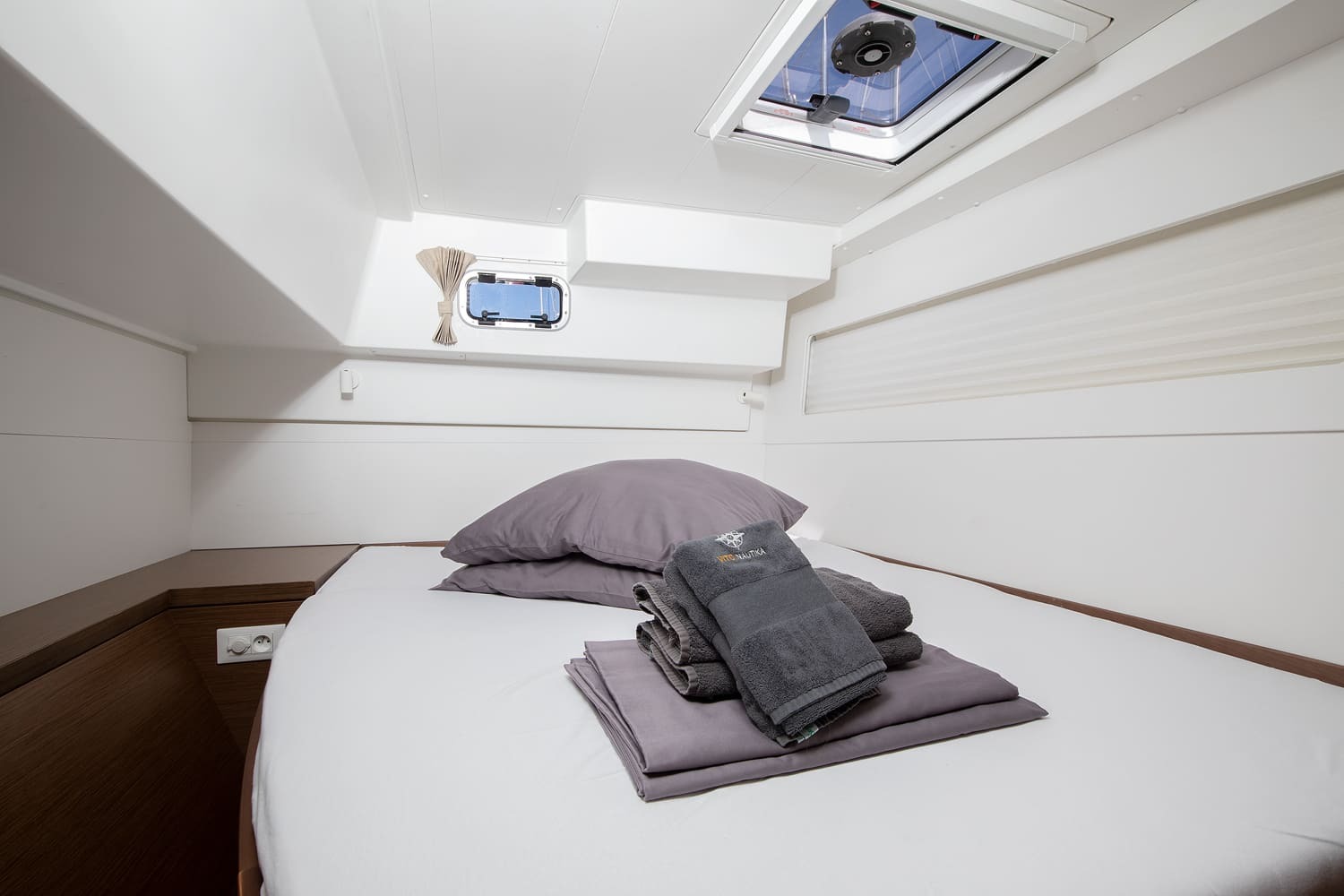 Bow cabin with made-up double berth, overhead hatch and opening porthole, with Vito Nautika towels