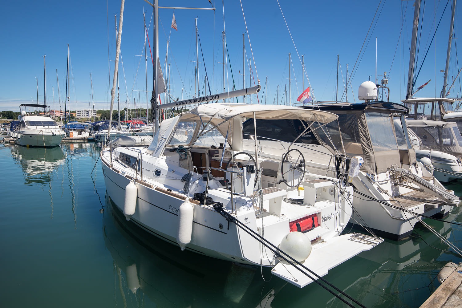 Beneteau Oceanis 35 alongside in the marina, mast and rigging against the sky