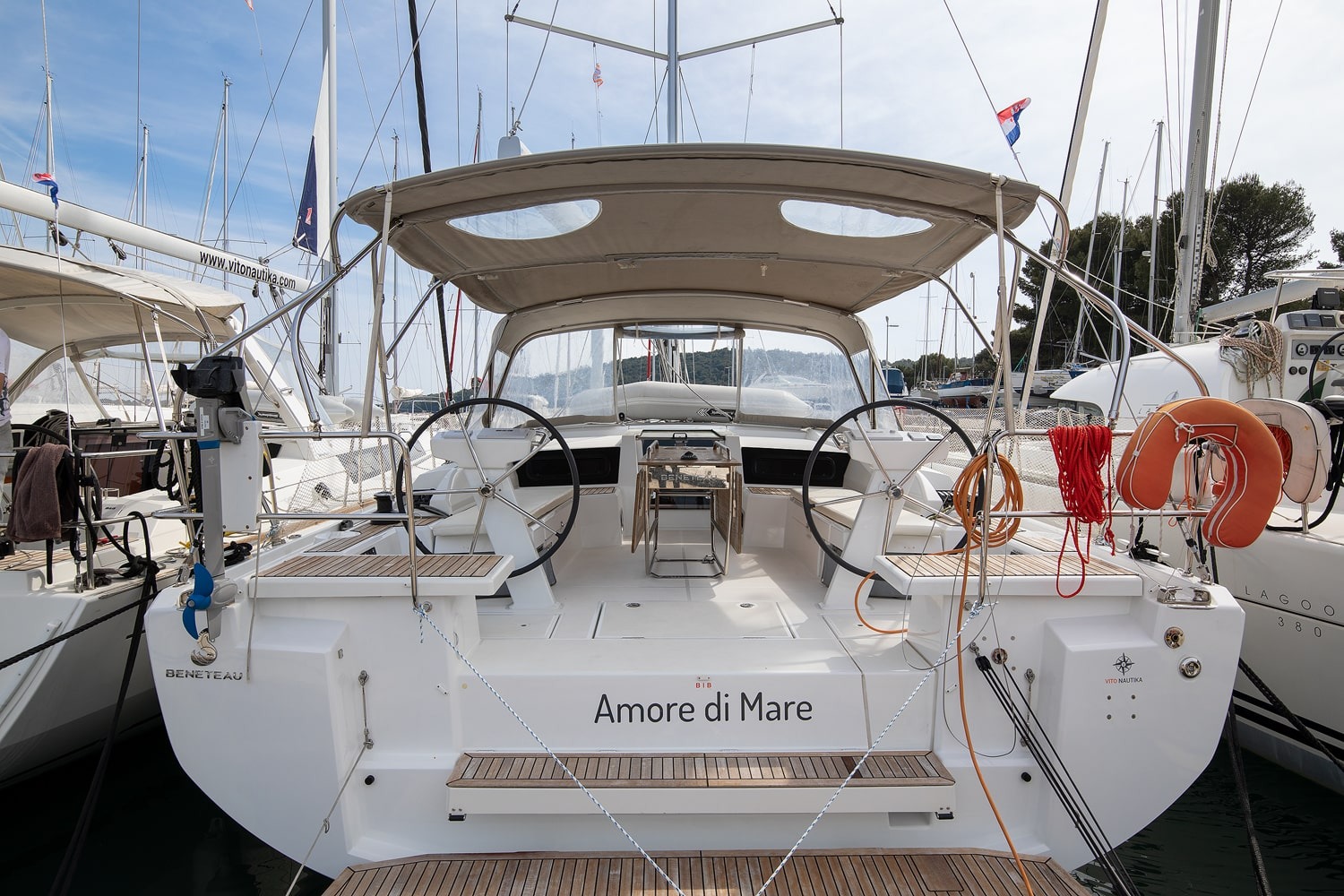 Amore di Mare, a 2022 Beneteau Oceanis 46.1, viewed from astern in ACI Marina Pomer, showing the twin wheels, teak cockpit and bimini top