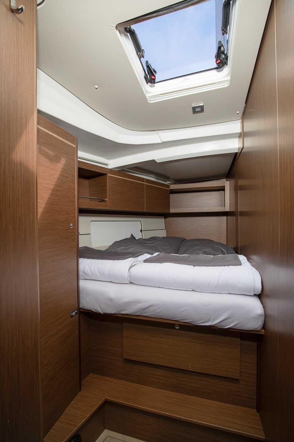 A double cabin aboard Amore di Mare, with a wide berth, reading lights and a hull window