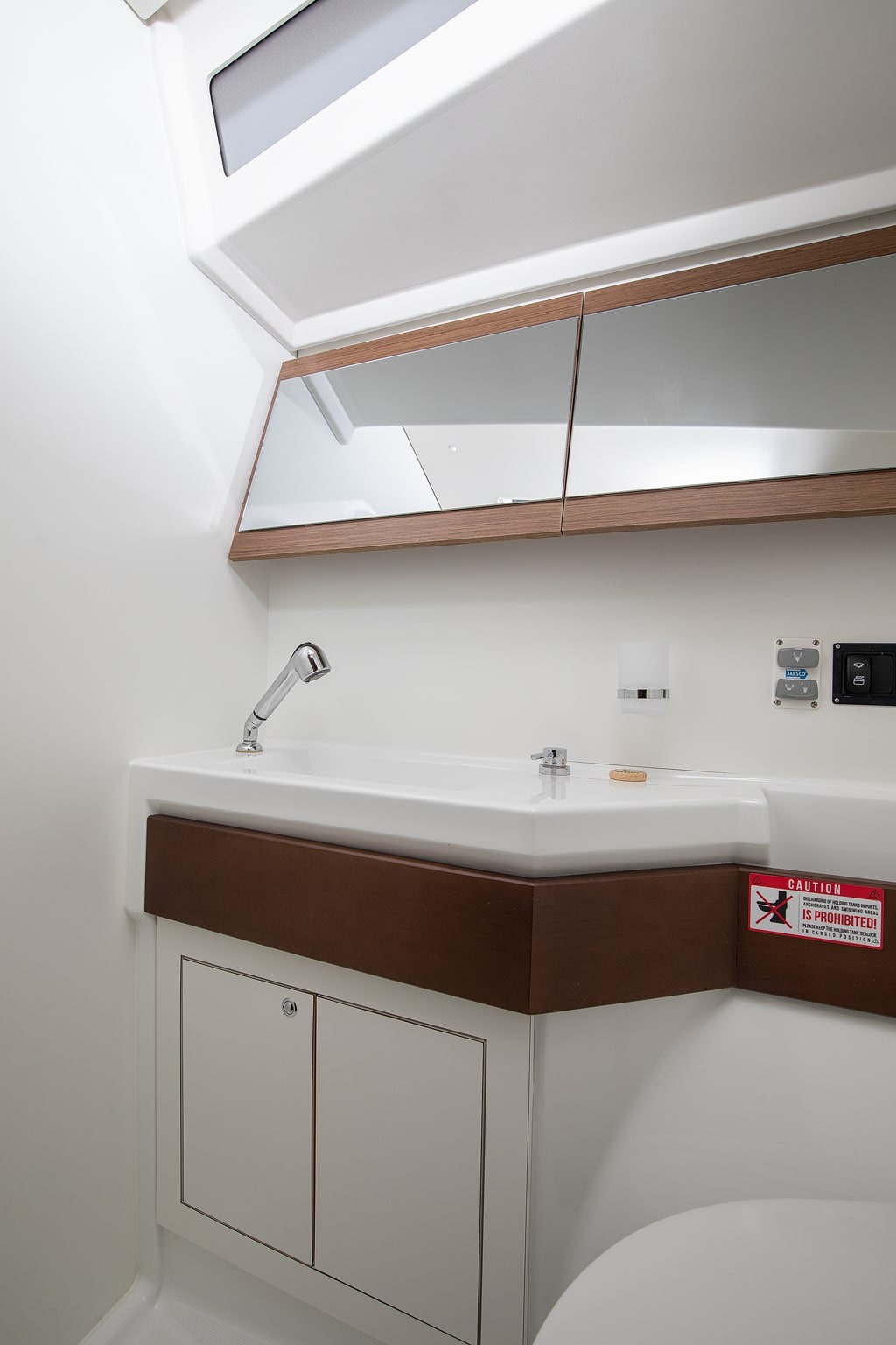 A heads compartment aboard Amore di Mare, with washbasin, mirror and wooden vanity top