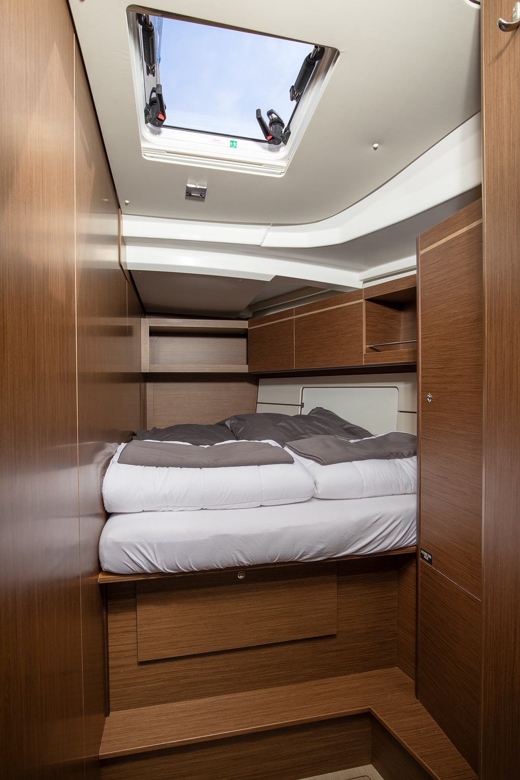 A guest cabin aboard Amore di Mare, with the berth made up and towels laid out