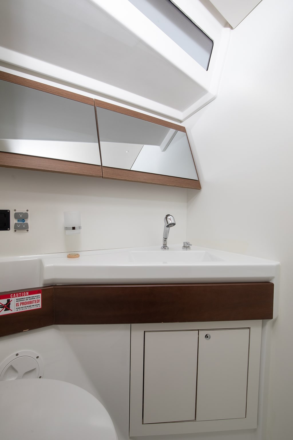 A second heads compartment aboard Amore di Mare, with washbasin, storage shelf and overhead lighting