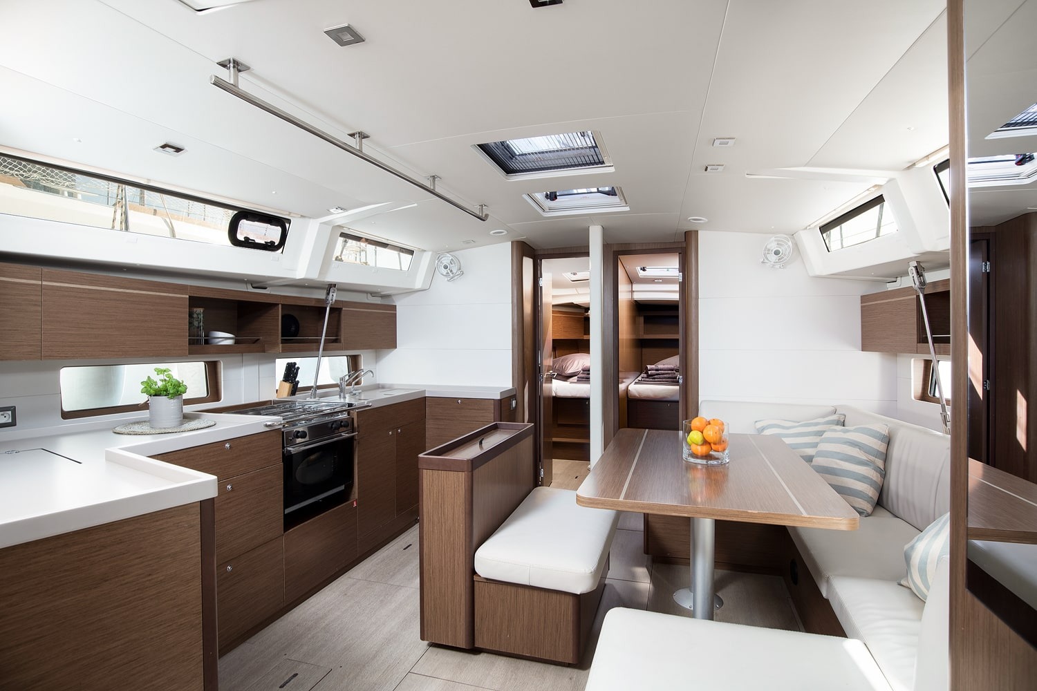 Saloon of the Vento di Mare with the galley to one side, dining table and large windows.