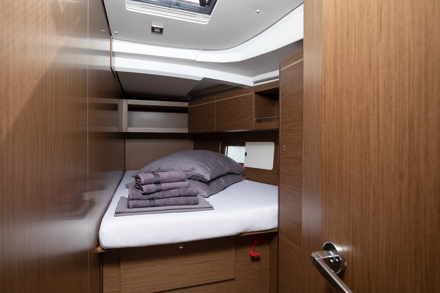 Guest cabin of the Vento di Mare with double berth and hull window.
