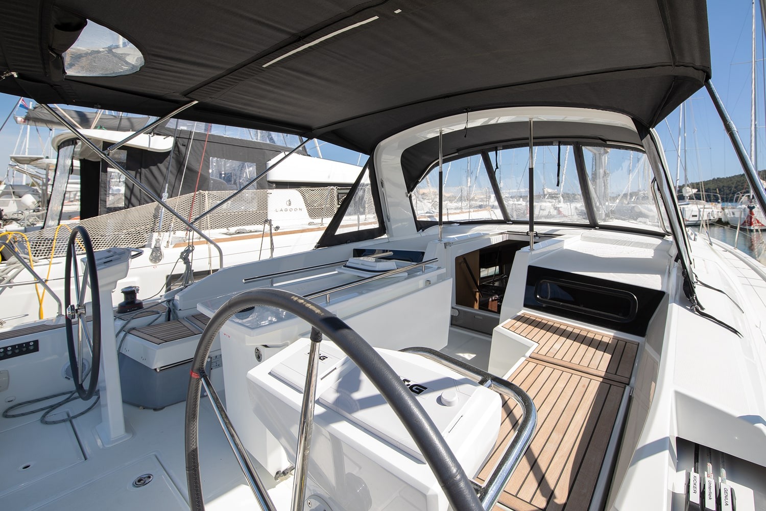 Cockpit of the Vento di Mare under the bimini, with the wooden cockpit table and twin helm stations.