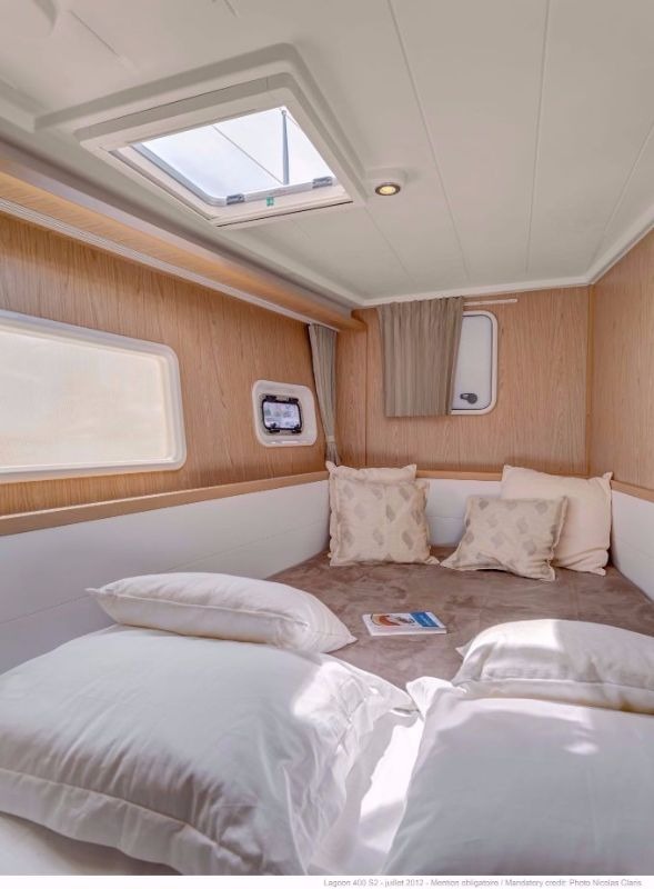 Double cabin in the hull of a Lagoon 400 catamaran, with a hull window, opening portlight and overhead hatch above the berth