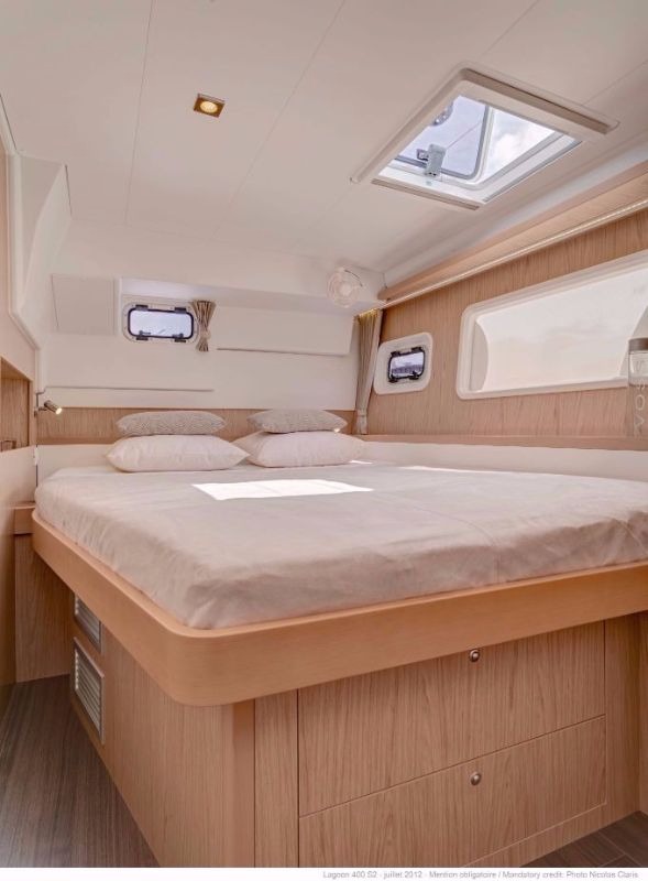 Double cabin in the hull of a Lagoon 400 catamaran, with the berth against the hull side, storage drawers below and an overhead hatch