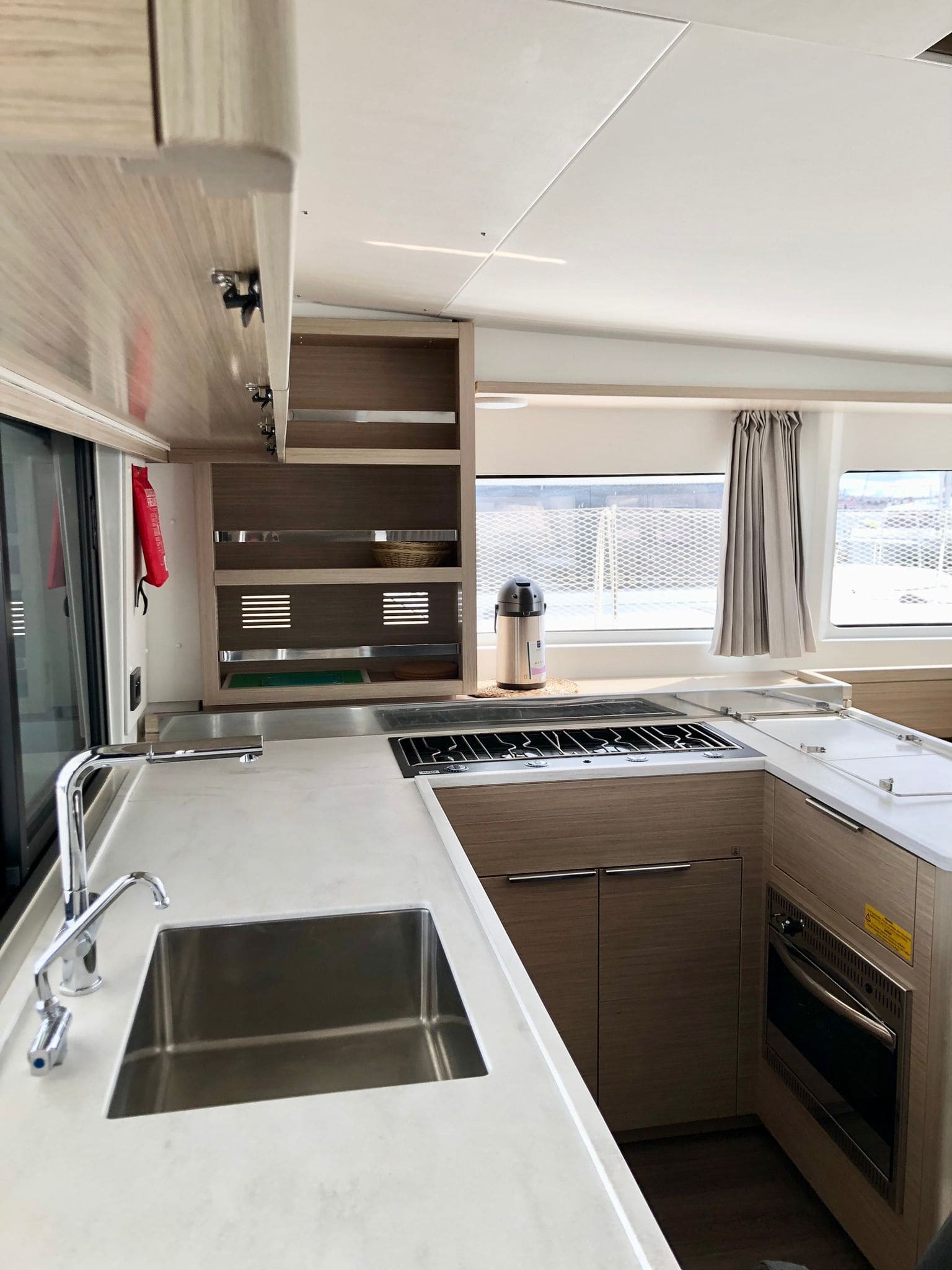 Galley aboard the Lagoon 46 Venice Beach, with gas hob, oven, stainless sink and light oak cabinetry