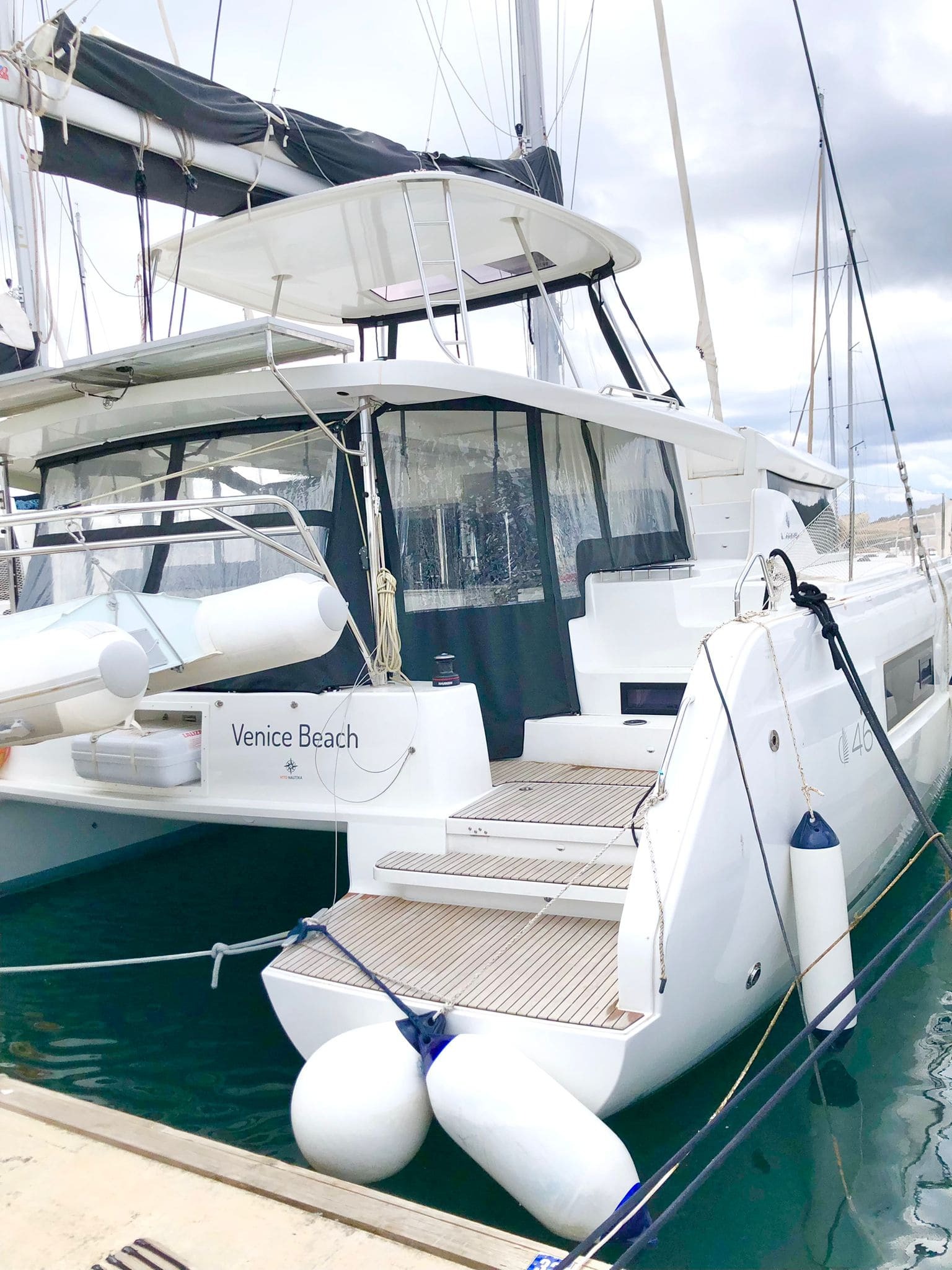 Venice Beach, a Lagoon 46 catamaran, moored stern-to with her name on the transom and teak bathing platforms between the hulls