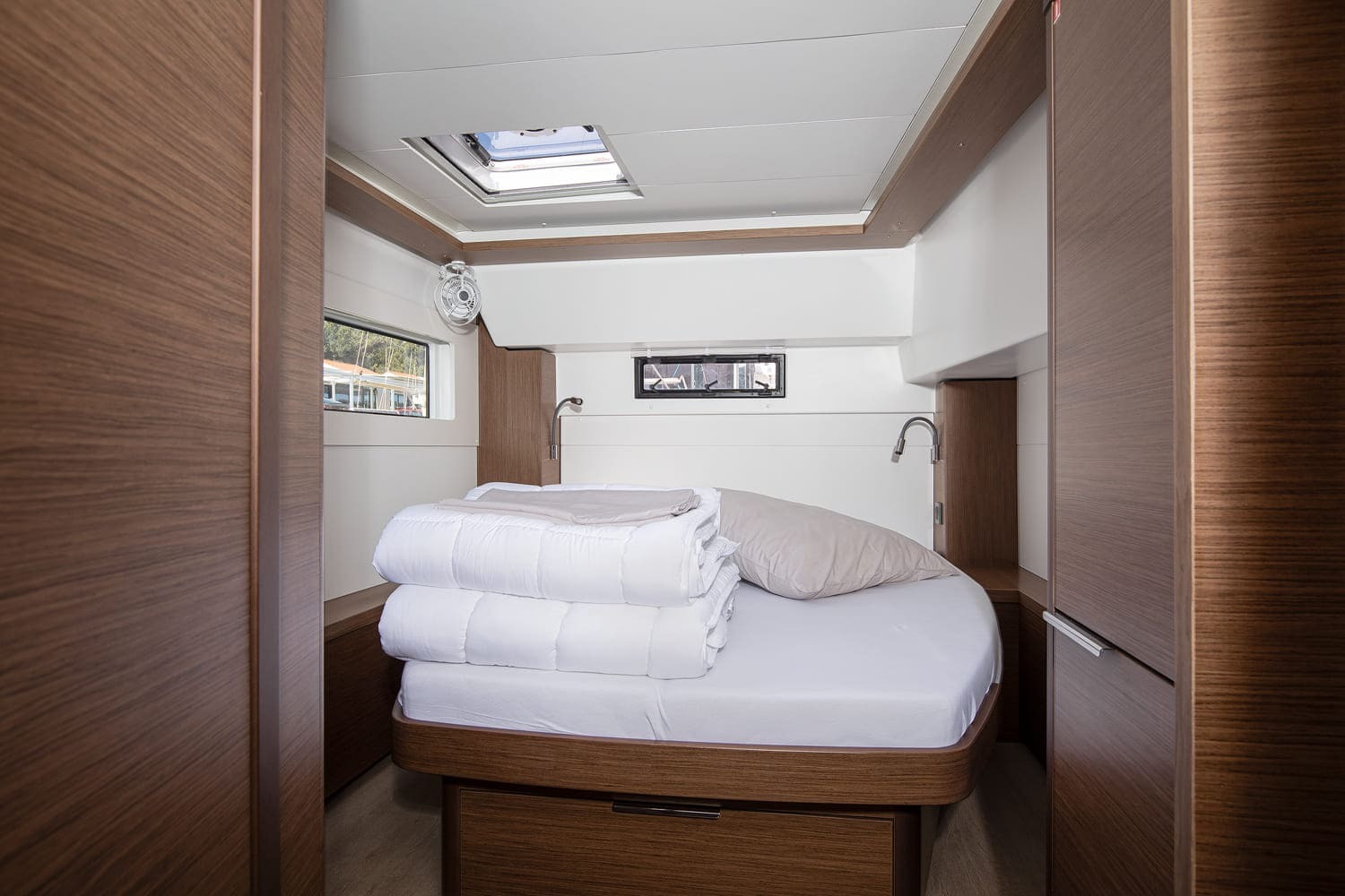 Double cabin aboard the Lagoon 46 Venice Beach, with island berth, overhead hatch, reading lights and dark oak joinery