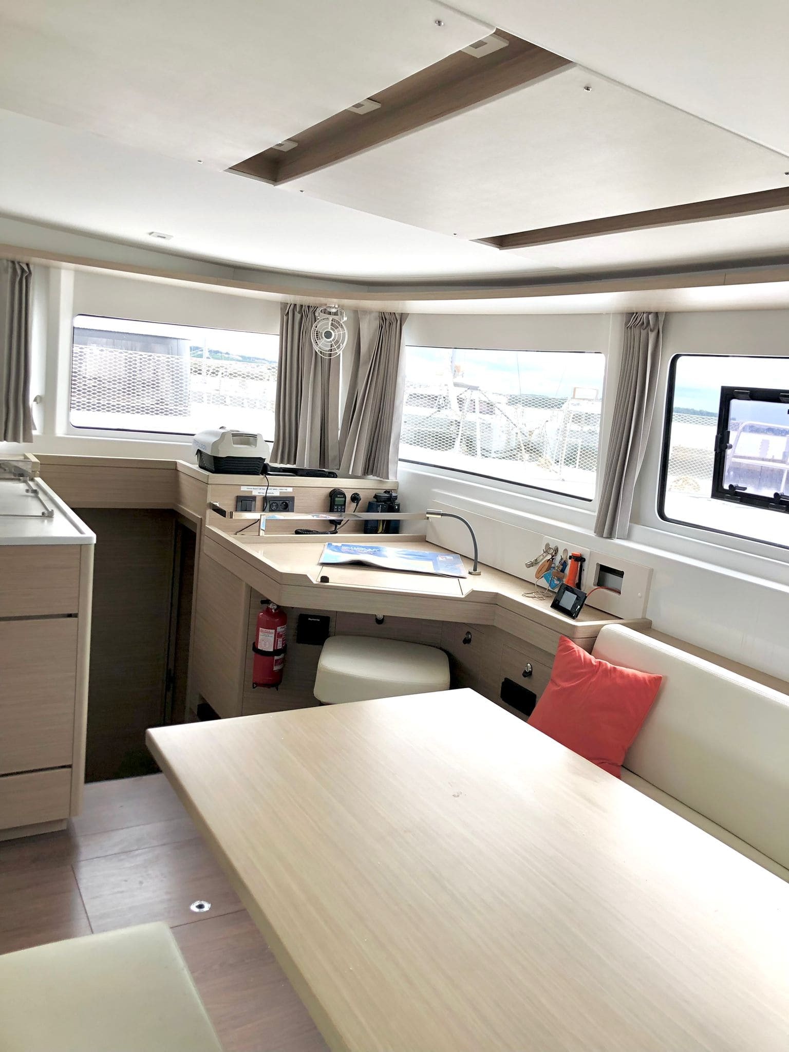 Saloon of the Lagoon 46 Venice Beach, with dining table, chart table and panoramic windows over the marina