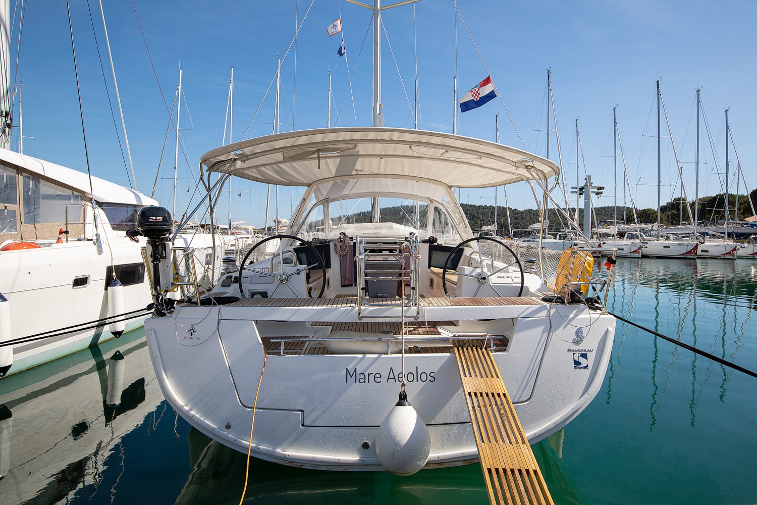 Mare Aeolos moored stern-to at ACI Marina Pomer, with twin helms, teak cockpit and bimini shading the deck