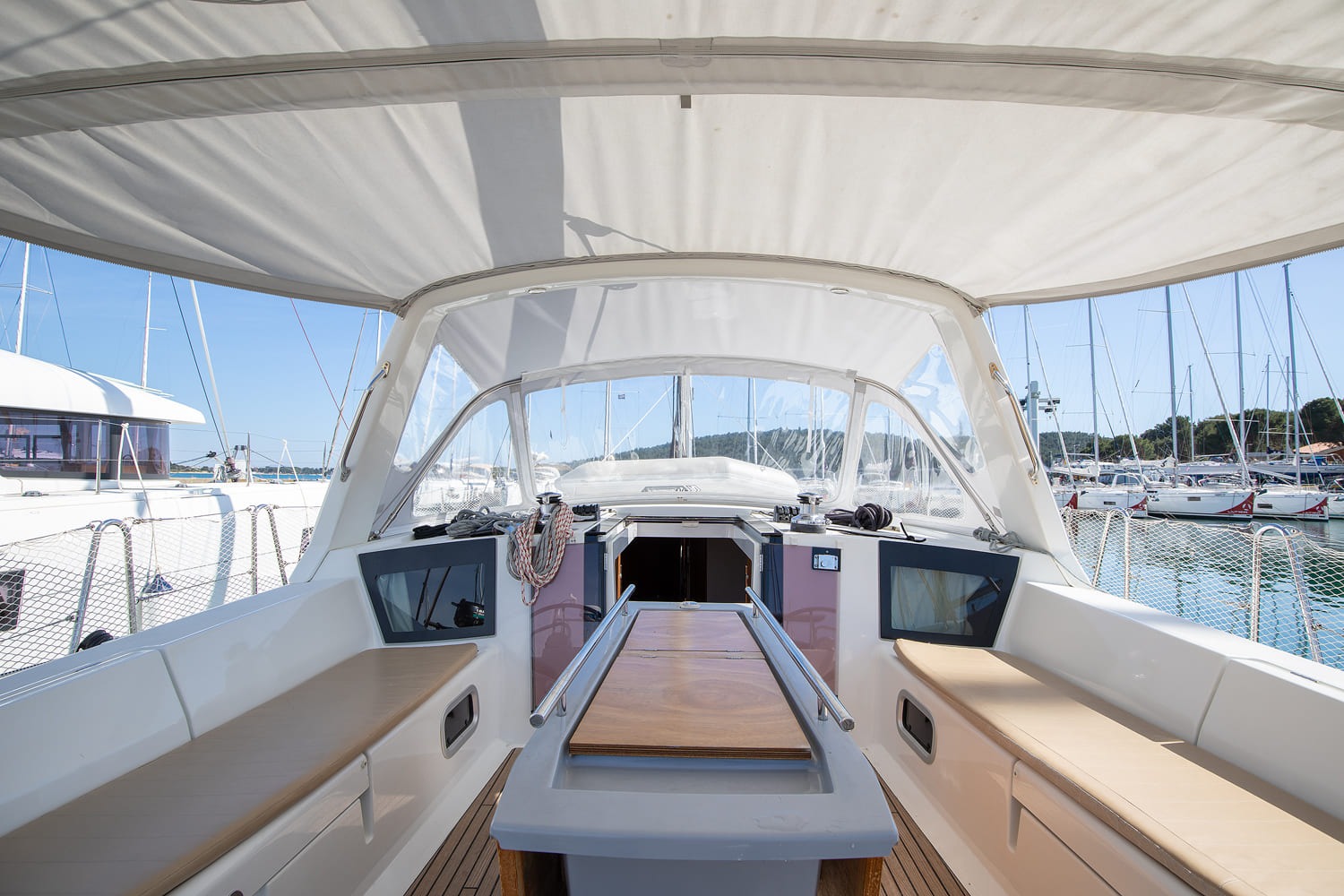 Cockpit seating and sprayhood of the Oceanis 45, with cushioned benches either side and the companionway open