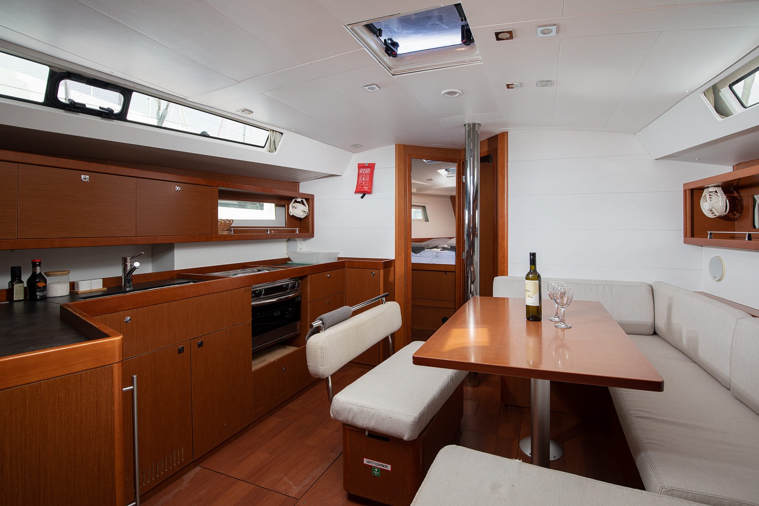 Saloon of Mare Aeolos looking forward, with galley to port, dining table and a cabin visible beyond