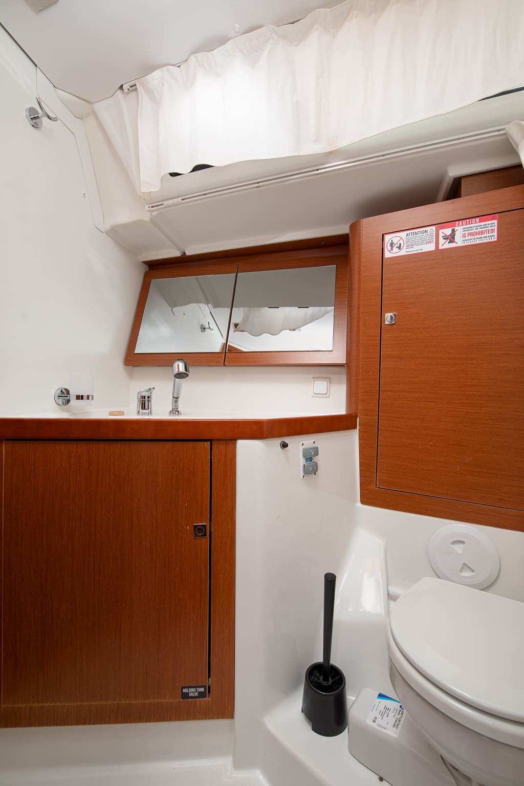 Heads compartment aboard Mare Aeolos, with electric toilet, washbasin, mirrored locker and shower curtain